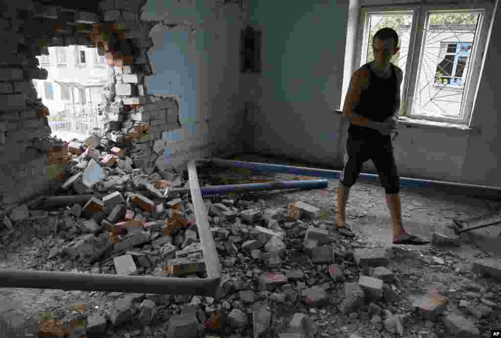 A prisoner inspects damage in a high-security facility after shelling in Donetsk, eastern Ukraine, Aug. 11, 2014.