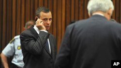Oscar Pistorius talks on a mobile phone while waiting for proceedings to get under way in court in Pretoria, South Africa, March 24, 2014.