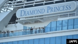 Sejumlah penumpang terlihat di geladak kapal pesiar Diamond Princess. Sekitar 3.600 orang dikarantina di atas kapal tersebut karena kekhawatiran virus korona di Pelabuhan Yokohama, Jepang, 13 Februari 2020. (Foto: AFP)