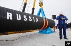 Seorang pekerja konstruksi Rusia berbicara di telepon seluler di Teluk Portovaya sekitar 170 km barat laut dari St. Petersburg, Rusia, Jumat, 9 April 2010. (Foto: AP)