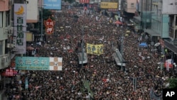 Tens of thousands of protesters march through the streets as they continue to protest an extradition bill, Sunday, June 16, 2019, in Hong Kong. (AP Photo/Vincent Yu)