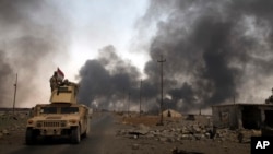 Des patrouilles des forces irakiennes surveillent les puits de pétrole en feu de Qayara, au sud de Mossoul, Irak, le 31 août 2016. 