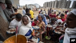 Des Tigréens déplacés font la queue pour recevoir de la nourriture donnée par des résidents locaux dans un centre d'accueil pour personnes déplacées à Mekele, dans la région du Tigré au nord de l'Éthiopie le dimanche 9 mai 2021. (AP/Ben Curtis)