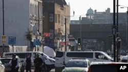 Sebuah tenda forensik dan polisi terlihat di Seven Sisters Road menuju Masjid Finsbury Park pasca insiden sebuah kendaraan menabrak pejalan kaki di London utara, 19 Juni 2017. (AP Photo/Tim Ireland).