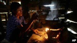 A local villager cooks dinner in Ta Thorng village, in Koh Kong province, some 140 kilometers (87 miles) west of Phnom Penh, Cambodia, Thursday, Nov. 22, 2012. Like many poor people in rural Cambodia, she has no electricity and uses a small wood burning stove to cook rice, the staple food nationwide. (AP Photo/Heng Sinith)