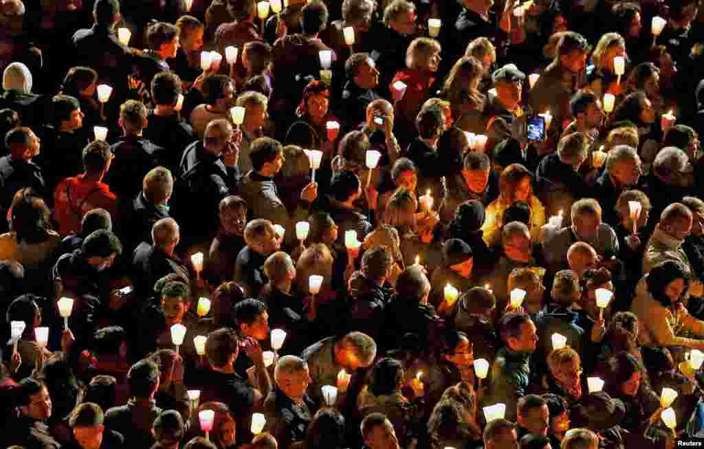 Faithful attend the "Via Crucis" (Way of the Cross) procession, which commemorates the crucifixion of Jesus Christ, led by Pope Francis at the Colosseum in Rome, April 3, 2015.