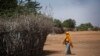 FILE - In this Dec. 19, 2017 file photo, a Somali refugee girl walks past the fence surrounding a hut at Dadaab refugee camp, hosting over 230,000 inhabitants, in northern Kenya.