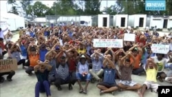 This photo made from Australia Broadcasting Corporation video taken on Oct. 31, 2017, shows asylum seekers protesting the possible closure of their detention center on Manus Island, Paua New Guinea.