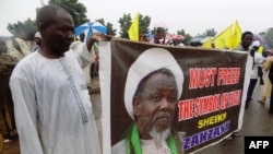 Des partisans du mouvement islamique pro-iranien au Nigeria (IMN) tiennent une banderole avec une photo du leader détenu Ibrahim Zakzaky dans la ville de Kano, au nord du Nigeria, le 11 août 2016.