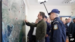 FILE - Greece's Prime Minister Kyriakos Mitsotakis points a map in the village of Feres, Evros region, at the Greek-Turkish border, March 3, 2020.