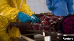 ma'aikatan lafiya su na daukar jini a jikin wata mace mai fama da cutar Ebola