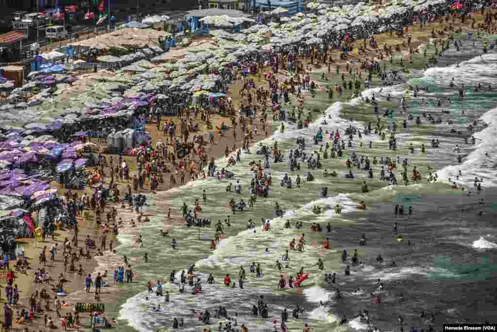 Egypt’s summer temperatures send a sea of people to the seashore at Miami Beach, in the port city of Alexandria.