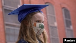 La niña Lydia Hassbroek se prueba su virrete para una fotografía para su graduación digital, en medio de la pandemia del coronavirus en Brooklyn, Nueva York. 11 junio de 2020.