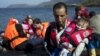A Syrian refugee holds a baby moments after arriving on a dinghy on the Greek island of Lesbos, Sept. 11, 2015. 