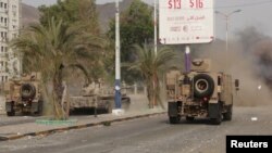 FILE - Military vehicles of the Southern Resistance fighters move during clashes with Houthi fighters on a street in Yemen's southern port city of Aden, July 17, 2015.