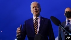 Le président américain Joe Biden avec des journalistes avant de monter à bord de l'avion présidentiel, le 30 novembre 2021, à Minneapolis-St. Paul, Minnesota.