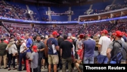 Partidarios del presidente Donald Trump, esperan que aparezca en el escenario, en su primer mitin de la campaña de reelección en varios meses en medio del brote de la (COVID-19), en el Centro BOK, en Tulsa, Oklahoma, el 20 de junio de 2020.