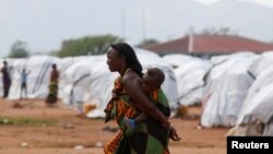FILE - An Ethiopian asylum seeker carries an infant in the Dambala Fuchana refugee camp near the Ethiopian-Kenyan border town of Moyale, Kenya, March 27, 2018.