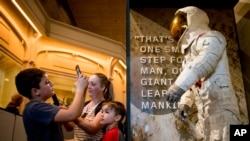 Algunos de los primeros visitantes en el Museo del Aire y Espacio, en Washington, el martes 16 de julio, para admirar el traje espacial restaurado que el astronauta Neil Armstrong usó en la misión Apolo 11 para ir a la Luna.