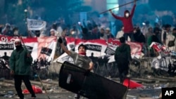 A supporter of Indonesian presidential candidate Prabowo Subianto throws rock at riot police during clashes in Jakarta, Indonesia, Wednesday, May 22, 2019. Indonesian President Joko Widodo said authorities have the volatile situation in the country's capital under control.