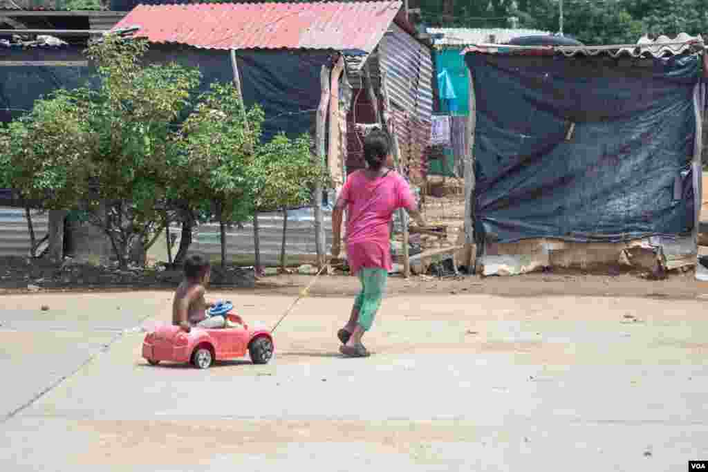 Una niña jala en su carrito a su hermano en La Pista, una zona cerca de la frontera colombo-venezolana en donde familias venezolanas viven bajo extremas condiciones de pobreza.
