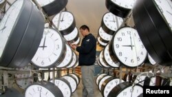A technician checks on the synchronization system at a workshop of a clock manufacturer in Yantai, Shandong province, China, Jan. 21, 2019. 