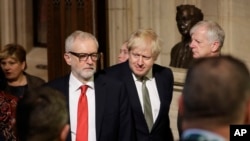 Britain's opposition Labour Party Leader Jeremy Corbyn, left, Prime Minister Boris Johnson, center right, walk through the Commons Members Lobby, during the state opening of Parliament, in London, Dec. 19, 2019.