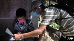 Guru SD Fransiscus Xaverius Fri Harna (R) mengajar muridnya belajar di rumahnya di Magelang, Jawa Tengah, setelah sekolah ditutup akibat wabah Covid-19, 20 Mei 2020. (Foto: AFP)