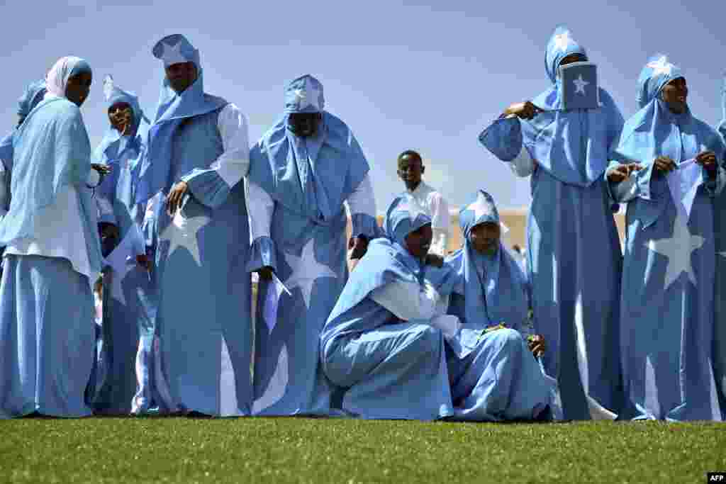 Para perempuan mengenakan bendera nasional Somalia untuk merayakan Hari Kemerdekaan negara itu di stadion Konis di Mogadishu.