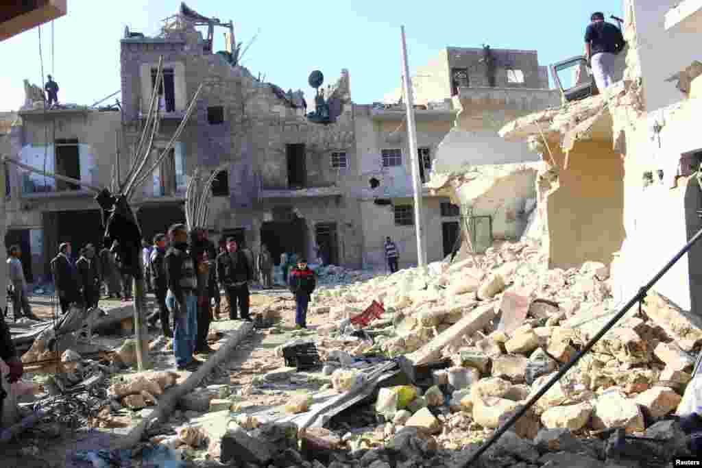 Warga melihat-lihat kerusakan di sebuah lokasi menyusul apa yang oleh para aktivis disebut serangan udara oleh pasukan pendukung setia Presiden Suriah Bashar al-Assad di Karam Al-Beik, Aleppo (21/1).