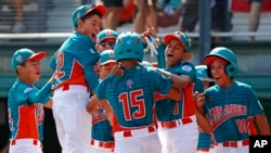 Maracaibo, Venezuela's Jonney Rosario (15) celebrates with teammates after hitting a two-run home run during the first inning of an International pool play baseball game against White Rock, British Columbia. (AP Photo/Gene J. Puskar) 