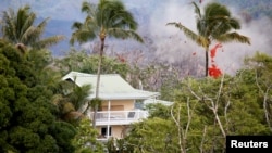 Smoke and lava erupt from a fissure near a home on the outskirts of Pahoa during ongoing eruptions of the Kilauea Volcano in Hawaii, May 14, 2018.