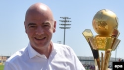 Le président de la FIFA, Gianni Infantino, tient un trophée dediés aux "travailleurs de la Coupe du au Qatar 2016" à Doha, Qatar, 22 avril 2016. epa/ STRINGER