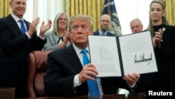 Presiden Donald Trump memperlihatkan panduang pembentukan Angkatan Antariksa, "Space Policy Directive 4", setelah menandatangani angkatan keenam Angkatan Bersenjata AS di Ruang Oval, Gedung Putih, di Washington, 19 Februari 2019. 
