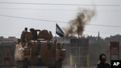 Pejuang oposisi Suriah yang didukung Turki dengan kendaraan pengangkut personel lapis baja untuk menyeberangi perbatasan ke Suriah, di Akcakale, provinsi Sanliurfa, Turki tenggara, 18 Oktober 2019. (Foto: AP/Emrah Gurel)