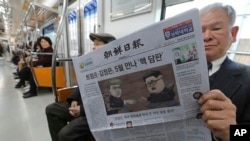 Seorang penumpang kereta bawah tanah di Seoul, Korea Selatan, membaca surat kabar dengan tajuk rencana pertemuan puncak antara pemimpin Korea Utara Kim Jong-un dan Presiden A.S. Donald Trump (kanan), 10 Maret 2018. (Foto: dok).